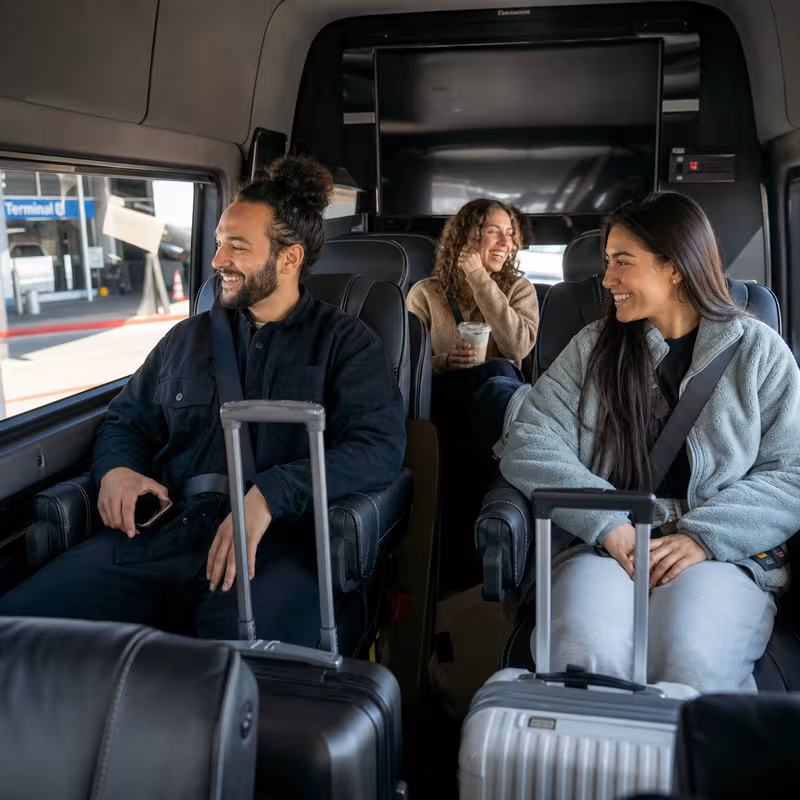 Passengers loading luggage while boarding an Arlington group shuttle