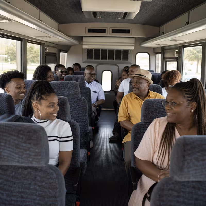 Group boarding a white charter bus for Private Event Transportation transportation in Arlington