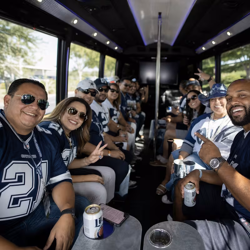 Group boarding a white charter bus for Sporting Event Transportation transportation in Arlington